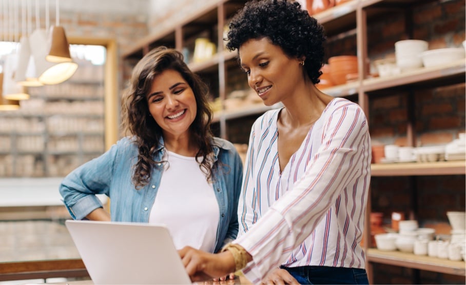 Enhancing-Employee-Engagement-with-AI-Driven-Solutions-Two-women-in-retail-store-by-a-laptop